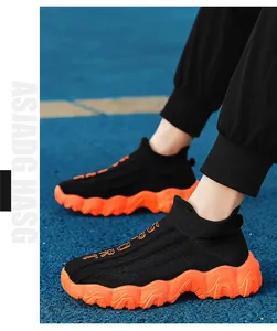 Nahaufnahme der schwarzen Flyknit-Söckchen-Sneaker mit leuchtend oranger Plateausohle.