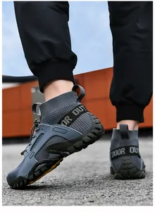 Dettaglio macro di sneaker outdoor grigie traspiranti high-top con suole in gomma.