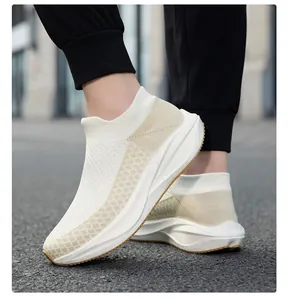 Close-up of cream fly-knit sock sneakers showing the slip-on design and thick sole