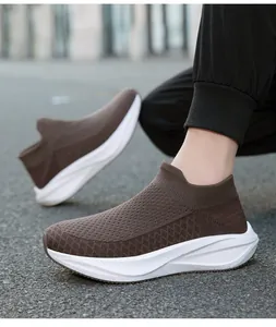Detailed side view of brown fly-knit sock shoes with thick white soles on asphalt