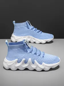 Detailed side view of light blue breathable knit sock sneakers with thick wavy white sole.