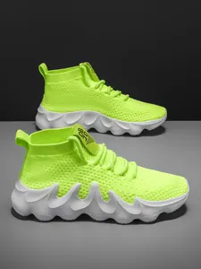 Side detail view of neon green fly-knit sports sneakers featuring a unique wavy white sole