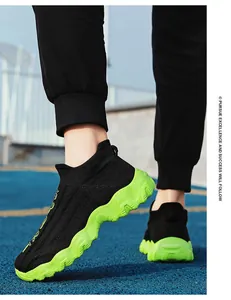 Detailansicht schwarzer Fly-Knit Socken-Sneaker mit neongrünen Sohlen auf einer Laufbahn