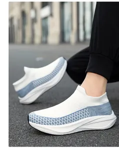 Detailed side view of white fly-knit slip-on sneakers featuring blue diamond mesh patterns