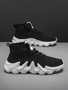 Detailed side view of black breathable knit sock sneakers featuring chunky white wavy soles.