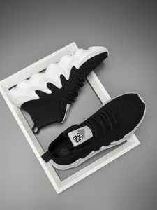 Lightweight black fly-knit running shoes with chunky wavy white soles for active men.