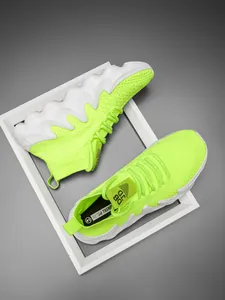 Detail of fluorescent green breathable knit sock sneakers with wave-shaped white soles