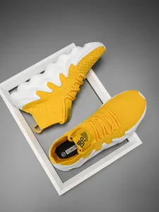Macro view of yellow flyknit walking shoes with stylish white wavy thick soles