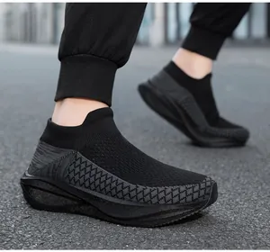 Detailed view of black breathable knit slip-on sneakers being worn for outdoor walking