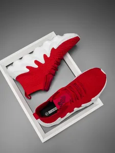 Detail of red breathable mesh sock sneakers with chunky wavy white soles in a frame