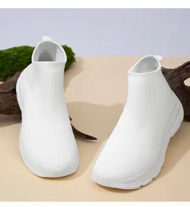 Makroansicht von weißen, atmungsaktiven Strickschuhen auf natürlichem Holzhintergrund