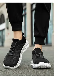 Primo piano di scarpe da ginnastica in maglia nera con suole bianche sulla strada