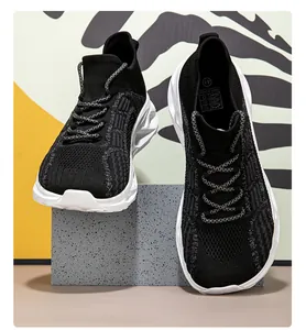 Vista dettagliata delle sneakers nere traspiranti in fly-knit presentate su un blocco grigio