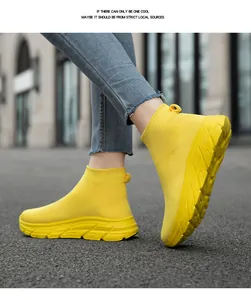 Leuchtend gelbe Fly-Knit Socken-Sneaker in einer Nahaufnahme beim Gehen im Freien