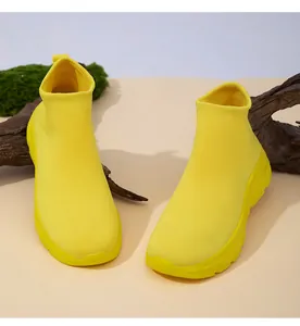 Nahaufnahme gelber, atmungsaktiver Fly-Knit-Socken-Sneaker auf natürlichem Holzgrund