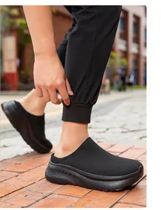 Detailed view of comfortable black knit mule shoes with a thick sole worn outdoors.