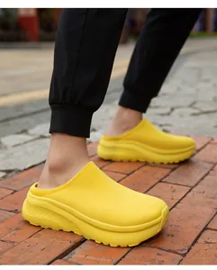 Close-up of vibrant yellow knit slip-on clogs with thick soles on brick pavement