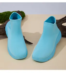 Detailansicht hellblauer atmungsaktiver Strick-Sneaker auf natürlichem Holzsockel