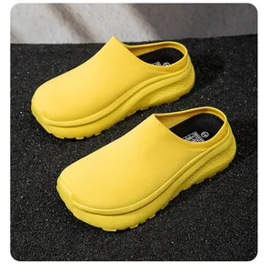 Detail view of bright yellow platform casual clogs on a dark granular textured surface