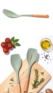Detail view of sage green silicone spatula and slotted spoon with wooden handles