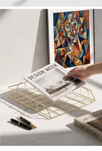 Elegant gold wire mesh file tray for desk organization in a modern study setting.