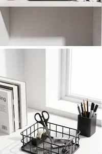 Modern black iron mesh storage basket on a white desk with office stationery and natural light