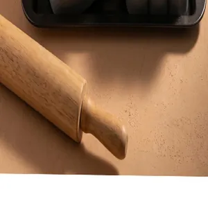 Détail d'une poignée de rouleau à pâtisserie en bois montrant le grain naturel
