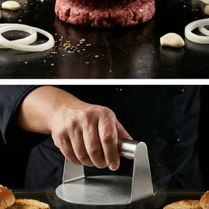 Close-up of stainless steel burger press used on a griddle by a professional chef
