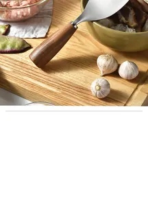 Close-up of titanium rice spoon with ergonomic acacia wood handle on a cutting board