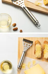 Detailed macro view of a stainless steel cheese slicer tool on a wooden cutting board