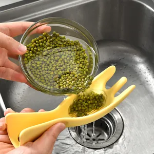 Multifunktionaler gelber Küchen-Reiswascher und Bohnensieb in einer Edelstahlspüle