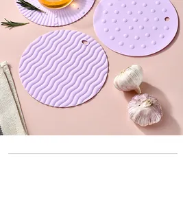 Detailed close-up of purple textured silicone pot holders with wavy and dotted patterns