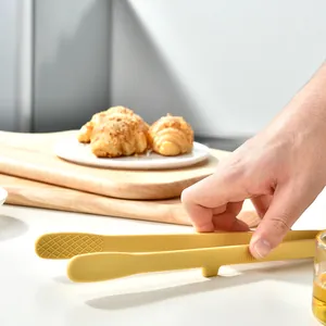 Professional food grade yellow silicone kitchen tongs used for serving bread or BBQ