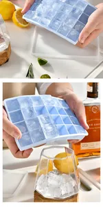 Macro view of flexible food-grade silicone ice tray releasing cubes into glass.