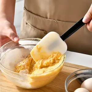 High-quality silicone spatula for baking cakes and cream, shown in use stirring dough in a bowl