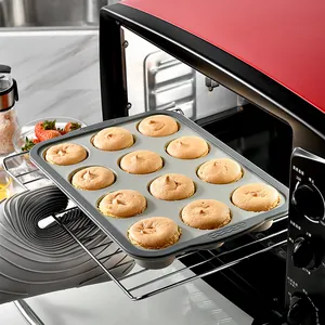 12-cup grey silicone muffin pan being removed from a toaster oven with baked muffins