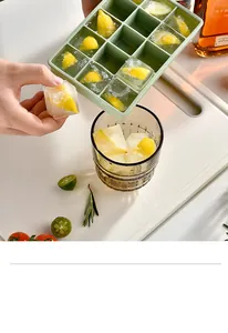 Detail view of hands removing a fresh lemon ice cube from a green 15-grid silicone tray