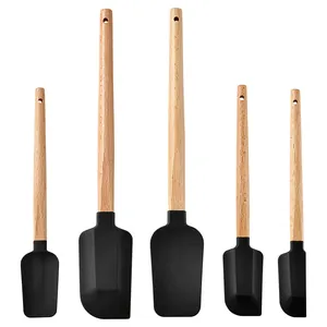 Detail view of five heat-resistant silicone spatulas with natural wood handles