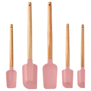 Detailed view of pink silicone baking spatula set with natural wood handles for versatile mixing