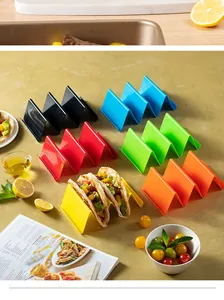 Set of colorful plastic taco holders displayed with fresh ingredients on a dining table