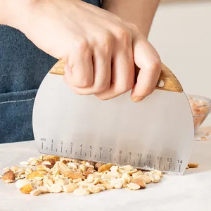 Stainless steel dough scraper with wooden handle for baking and chopping nuts.