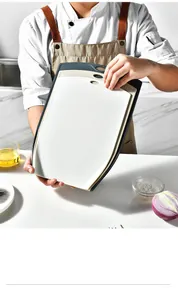 Close-up of a chef holding a set of three non-slip PP cutting boards in a kitchen scene