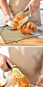 Close-up detail view of yellow silicone food tongs picking up a croissant and pasta