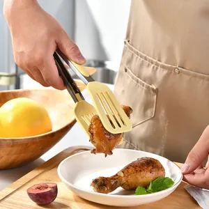 Heat resistant silicone and stainless steel kitchen tongs holding a cooked chicken drumstick.