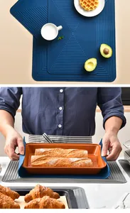 Heat resistant blue silicone dish drying mat used as a trivet for hot baking pans