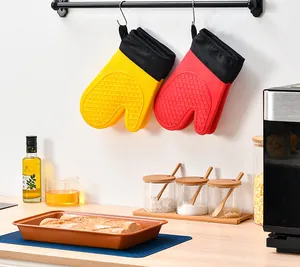 Yellow and red silicone oven mitts hanging in a bright, well-equipped kitchen scene.