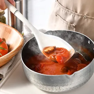 Heat-resistant white silicone cooking ladle scooping delicious tomato stew from a metal pot.