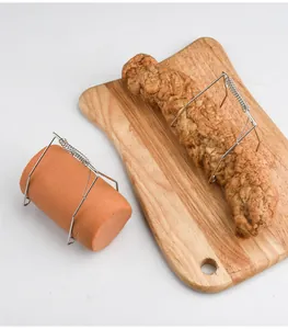 Close-up detail of 304 stainless steel spring clips holding meat rolls on wood