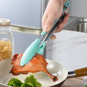 Pinze da cucina in acciaio inox per bistecche e barbecue in una scena di cucina reale