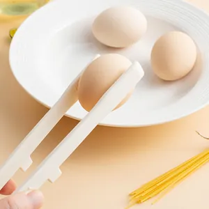 Heat resistant silicone kitchen tongs picking up an egg over a white plate background